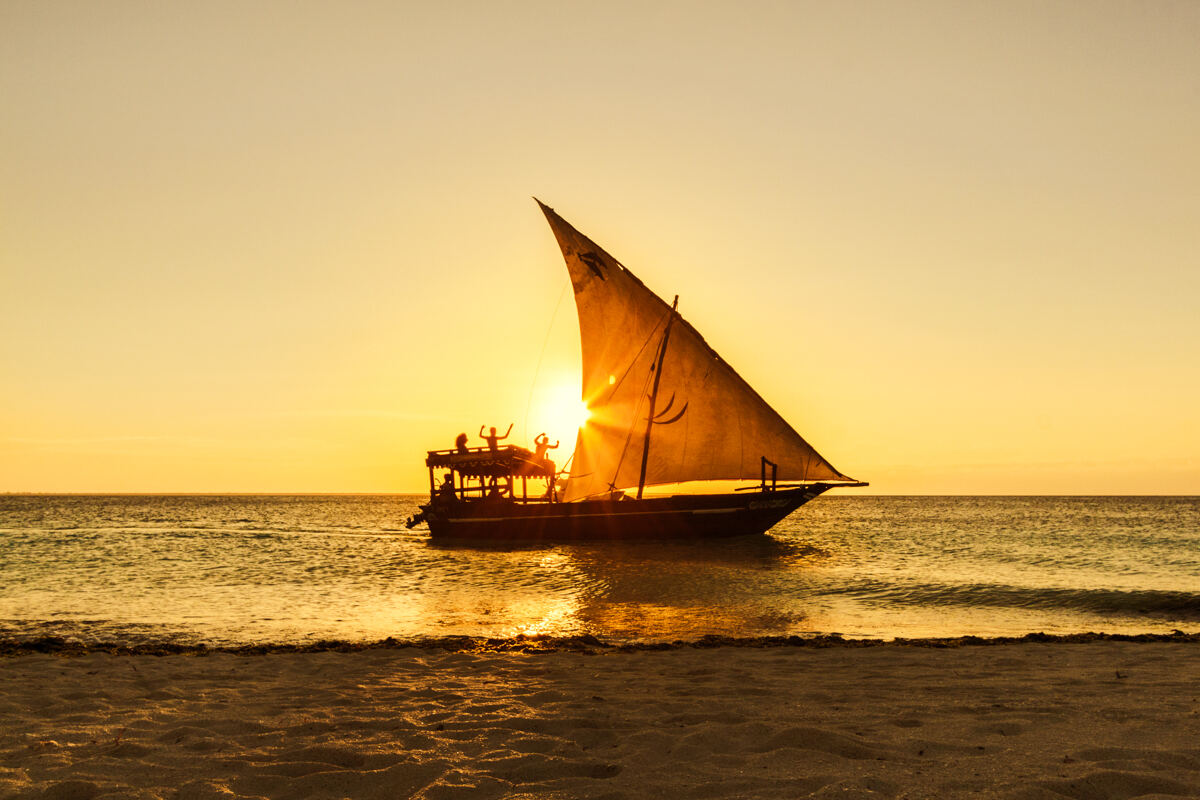 A traditional dhow sailing boat at sunset off Zanzibar